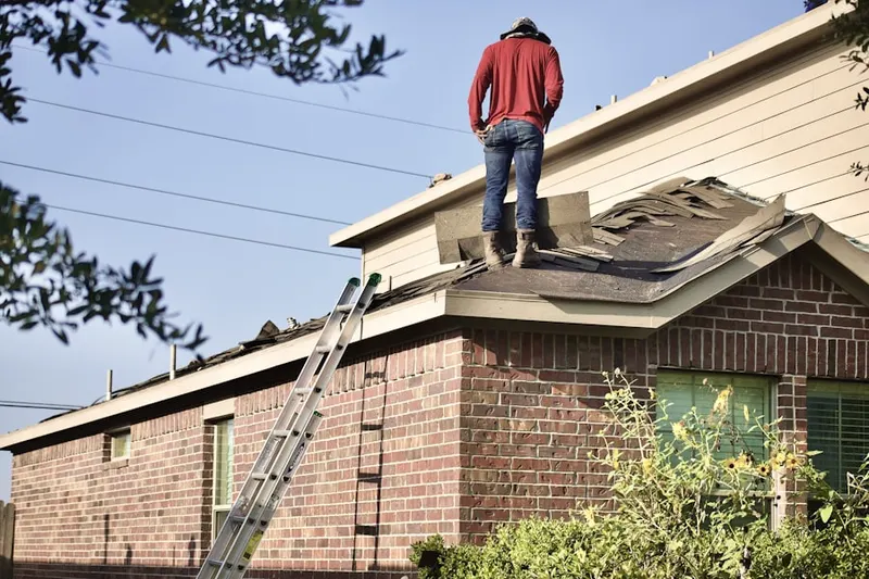 Professional roofer working on a residential roof in Brush Valley